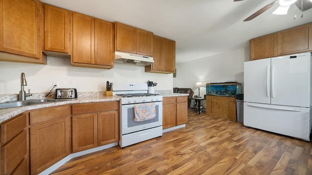 7837 Wagon Wheel Ln, Rockford, IL 61109 - kitchen featuring white appliances, under cabinet range hood, light wood-style flooring, a ceiling fan, and brown cabinets
