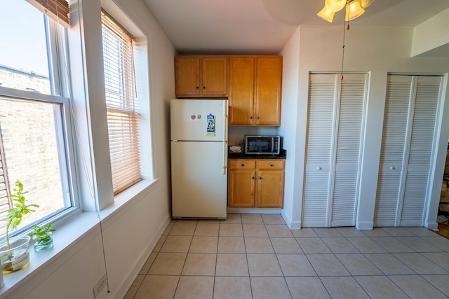 3043 N Laramie Ave Unit 2, Chicago, IL 60641 - kitchen featuring freestanding refrigerator, plenty of natural light, stainless steel microwave, and a ceiling fan