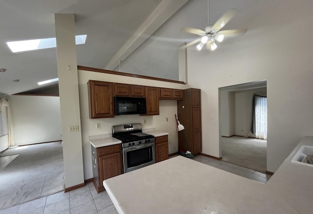 6130 N Jeffrey Ln, Oregon, IL 61061 - kitchen featuring black microwave, stainless steel range with gas stovetop, a skylight, light tile patterned floors, and high vaulted ceiling