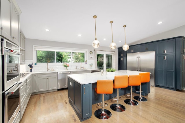 9050 Tamaroa Ter, Skokie, IL 60076 - kitchen with stainless steel appliances, backsplash, a center island, a breakfast bar, and recessed lighting