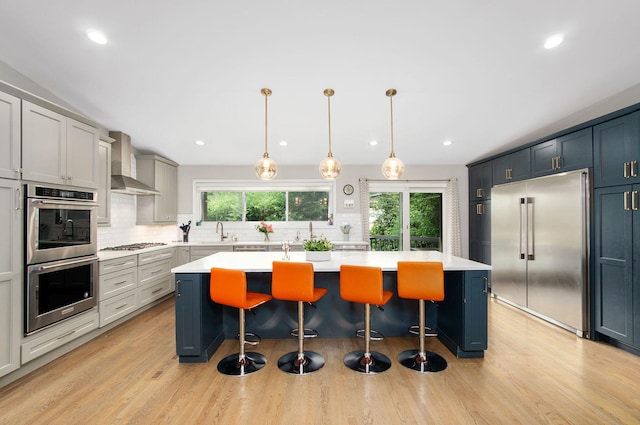 9050 Tamaroa Ter, Skokie, IL 60076 - kitchen featuring stainless steel appliances, wall chimney exhaust hood, decorative backsplash, light countertops, and recessed lighting