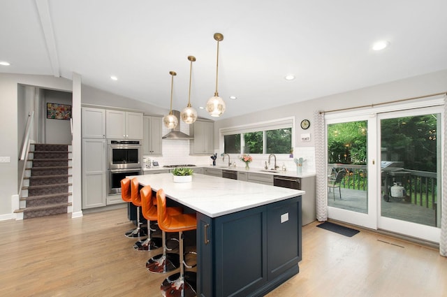 9050 Tamaroa Ter, Skokie, IL 60076 - kitchen featuring stainless steel appliances, decorative backsplash, a center island, light wood-style floors, and vaulted ceiling
