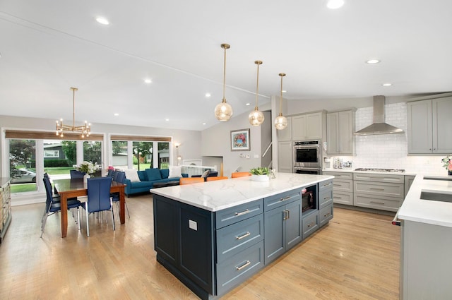 9050 Tamaroa Ter, Skokie, IL 60076 - kitchen with wall chimney exhaust hood, gray cabinetry, a kitchen island, backsplash, and recessed lighting