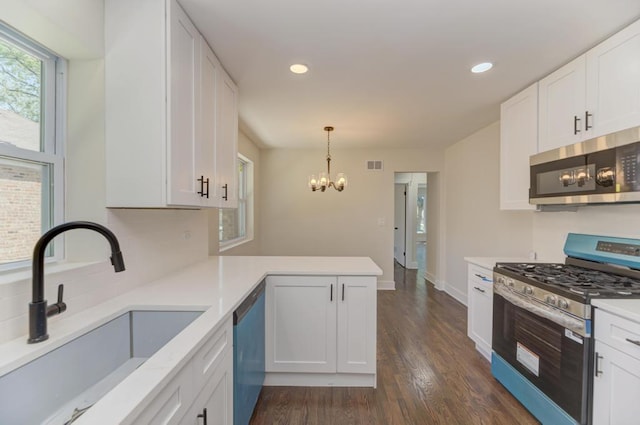 8916 S Sacramento Ave, Evergreen Park, IL 60805 - kitchen featuring appliances with stainless steel finishes, light countertops, a peninsula, white cabinets, and a chandelier