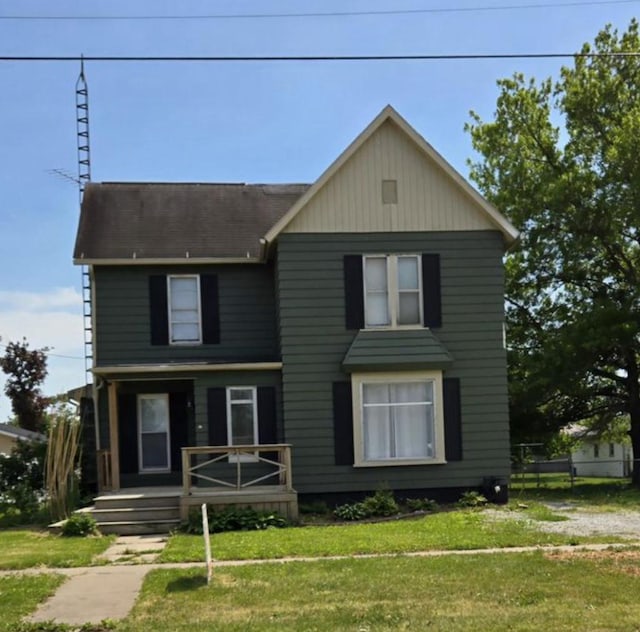 207 W Main St, La Harpe, IL 61450 - view of front of home featuring a front yard and roof with shingles