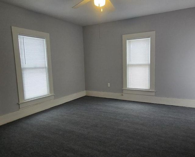 207 W Main St, La Harpe, IL 61450 - empty room featuring dark carpet, healthy amount of natural light, and a ceiling fan