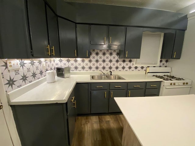 207 W Main St, La Harpe, IL 61450 - kitchen with white gas range, dark wood finished floors, light countertops, and backsplash