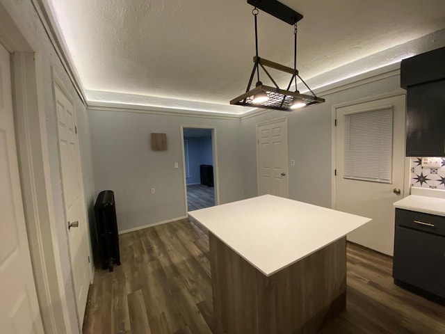 207 W Main St, La Harpe, IL 61450 - kitchen with dark wood finished floors, light countertops, a kitchen island, and pendant lighting