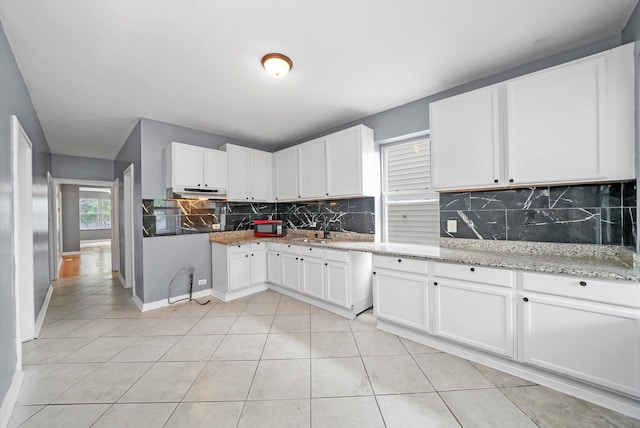 1438 S 50th Ct, Cicero, IL 60804 - kitchen with backsplash, light tile patterned floors, under cabinet range hood, and white cabinetry