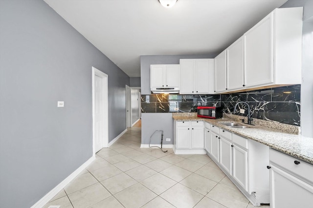 1438 S 50th Ct, Cicero, IL 60804 - kitchen with decorative backsplash, under cabinet range hood, white cabinets, and light tile patterned floors