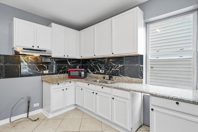 1438 S 50th Ct, Cicero, IL 60804 - kitchen with under cabinet range hood, light tile patterned floors, backsplash, and white cabinets