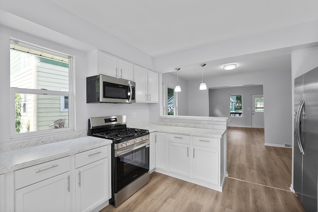541 N May St, Aurora, IL 60506 - kitchen featuring appliances with stainless steel finishes, a peninsula, light wood finished floors, and white cabinets
