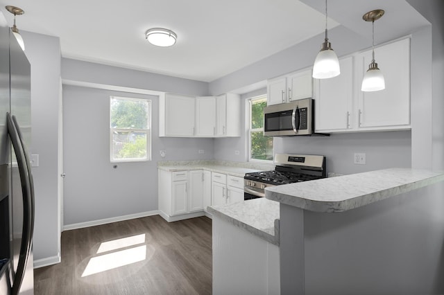 541 N May St, Aurora, IL 60506 - kitchen with stainless steel appliances, a peninsula, light countertops, dark wood-type flooring, and white cabinets