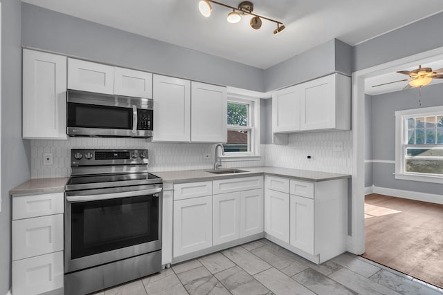 193 May St, Bensenville, IL 60106 - kitchen with stainless steel appliances, light countertops, white cabinetry, and plenty of natural light
