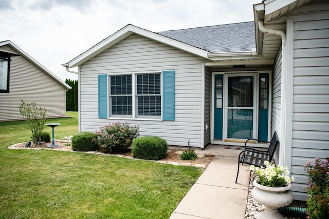 2107 10th Ave, Sterling, IL 61081 - view of exterior entry featuring a shingled roof and a yard