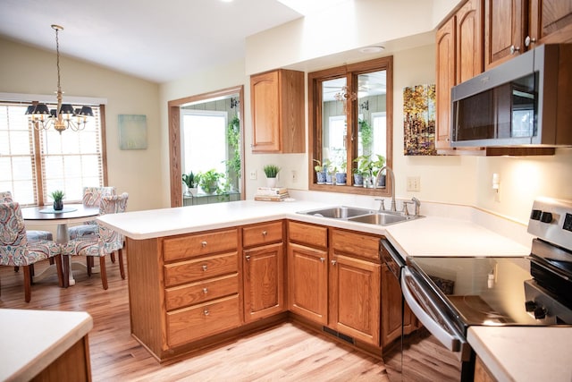 2107 10th Ave, Sterling, IL 61081 - kitchen with stainless steel appliances, light wood-style flooring, lofted ceiling, light countertops, and a chandelier