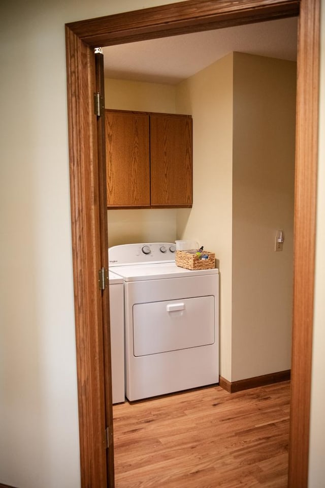 2107 10th Ave, Sterling, IL 61081 - laundry area featuring cabinet space and light wood-style floors