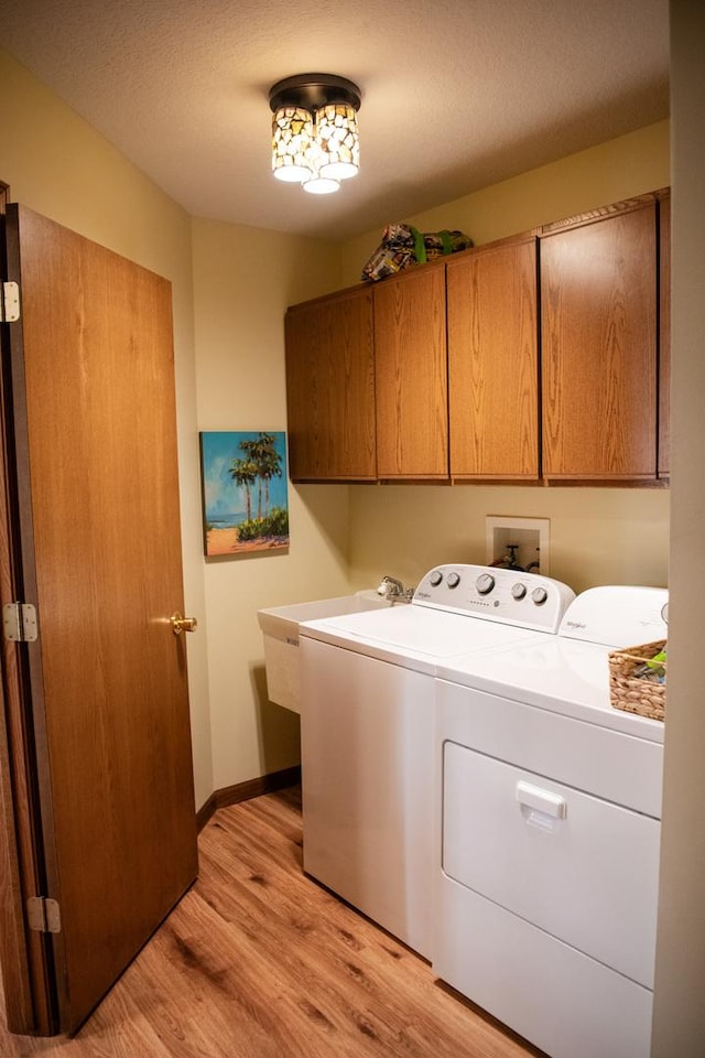 2107 10th Ave, Sterling, IL 61081 - laundry room featuring independent washer and dryer, cabinet space, and light wood-style floors