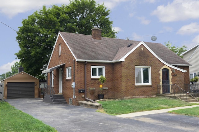 1411 E Hickory St, Streator, IL 61364 - view of front facade featuring an outbuilding, brick siding, roof with shingles, a detached garage, and a chimney