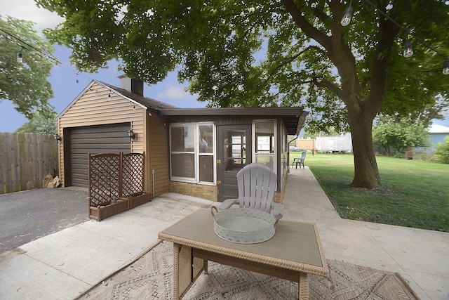1411 E Hickory St, Streator, IL 61364 - view of patio / terrace with a garage, driveway, and a sunroom