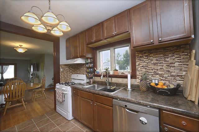 1411 E Hickory St, Streator, IL 61364 - kitchen featuring white gas range, dark countertops, stainless steel dishwasher, tasteful backsplash, and dark tile patterned flooring