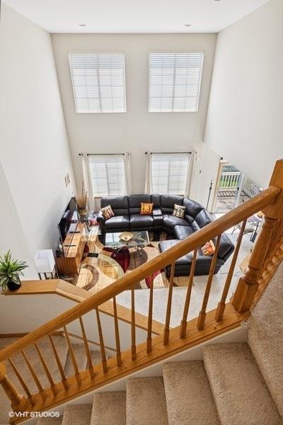 711 Creekside Cir Unit 711, Gurnee, IL 60031 - carpeted living room with a towering ceiling and stairway