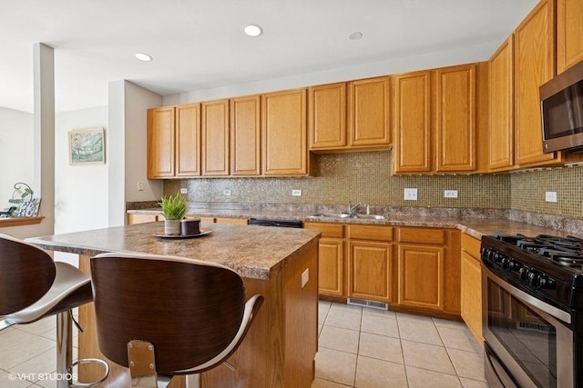 711 Creekside Cir Unit 711, Gurnee, IL 60031 - kitchen featuring stainless steel appliances, light tile patterned floors, a breakfast bar area, a kitchen island, and backsplash