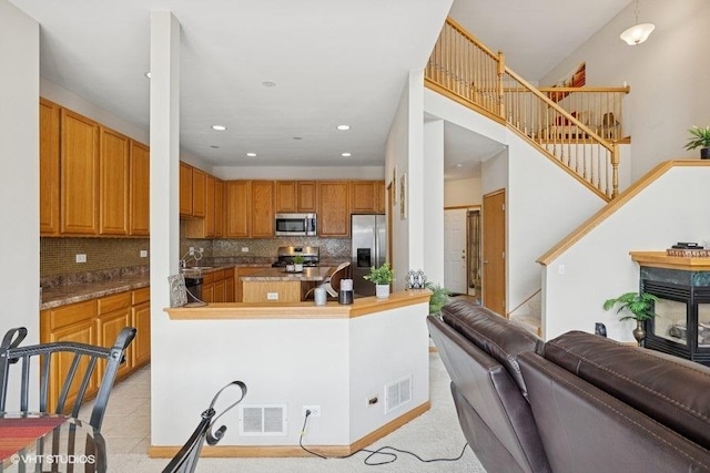 711 Creekside Cir Unit 711, Gurnee, IL 60031 - kitchen with stainless steel appliances, open floor plan, backsplash, brown cabinets, and recessed lighting