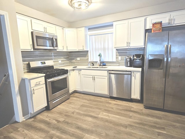 678 Muskegon Ave, Calumet City, IL 60409 - kitchen featuring appliances with stainless steel finishes, light countertops, white cabinets, backsplash, and light wood finished floors