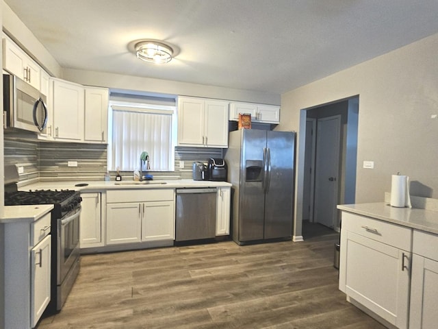 678 Muskegon Ave, Calumet City, IL 60409 - kitchen with appliances with stainless steel finishes, white cabinets, backsplash, and light countertops