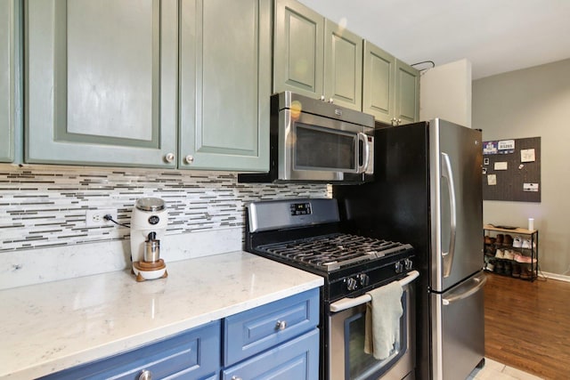 700 W Cornelia Ave Unit 3E, Chicago, IL 60657 - kitchen featuring appliances with stainless steel finishes, tasteful backsplash, light stone countertops, and light wood-style floors