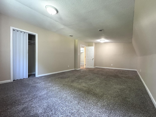 428 W Williams St, Kankakee, IL 60901 - unfurnished bedroom with dark carpet, a textured ceiling, and a closet