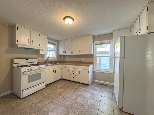 428 W Williams St, Kankakee, IL 60901 - kitchen with white appliances, under cabinet range hood, a textured ceiling, and light tile patterned floors