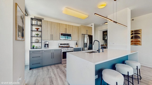 757 N Orleans St Unit 907, Chicago, IL 60654 - kitchen featuring appliances with stainless steel finishes, light wood-type flooring, a breakfast bar, open shelves, and modern cabinets