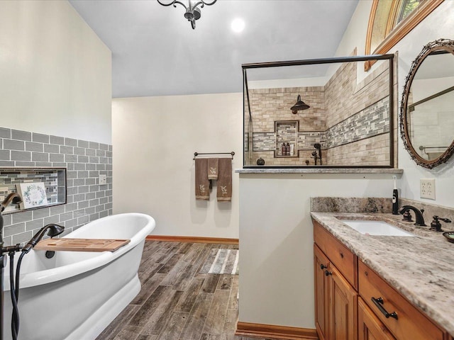 12828 Menominee Trl, Roscoe, IL 61073 - full bathroom with vanity, a soaking tub, wood finished floors, a tile shower, and tile walls