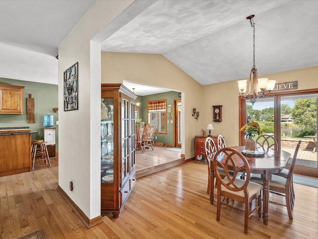 12828 Menominee Trl, Roscoe, IL 61073 - dining room featuring vaulted ceiling, light wood-style floors, and a chandelier