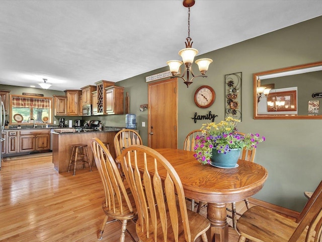 12828 Menominee Trl, Roscoe, IL 61073 - dining space with a chandelier and light wood-style flooring