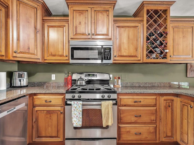 12828 Menominee Trl, Roscoe, IL 61073 - kitchen featuring stainless steel appliances, brown cabinets, and light stone counters