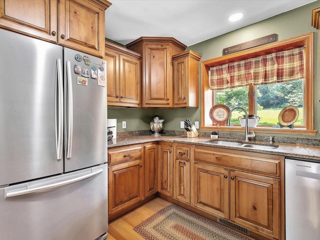 12828 Menominee Trl, Roscoe, IL 61073 - kitchen with stainless steel appliances, brown cabinets, light wood-type flooring, stone countertops, and recessed lighting
