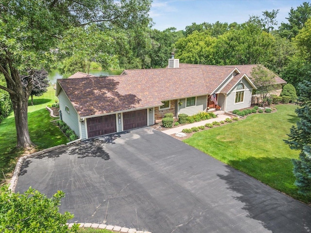 12828 Menominee Trl, Roscoe, IL 61073 - single story home with asphalt driveway, a garage, a front yard, and a chimney