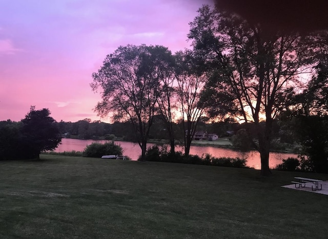 12828 Menominee Trl, Roscoe, IL 61073 - yard at dusk featuring a water view and a lawn