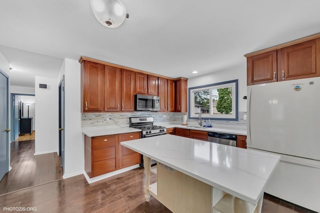 445 Kinkaid Ct, Des Plaines, IL 60016 - kitchen with stainless steel appliances, decorative backsplash, wood finished floors, a kitchen bar, and a kitchen island