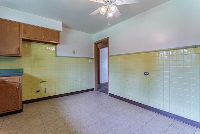 1481 Bloomingdale Rd, Glendale Heights, IL 60139 - kitchen with tile walls, a ceiling fan, light tile patterned flooring, brown cabinets, and wainscoting