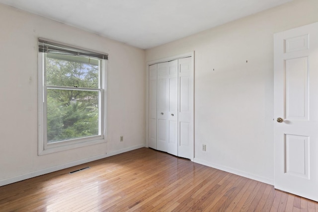 1485 Bryn Mawr Ln, Rockford, IL 61107 - unfurnished bedroom with multiple windows, light wood-style flooring, and a closet