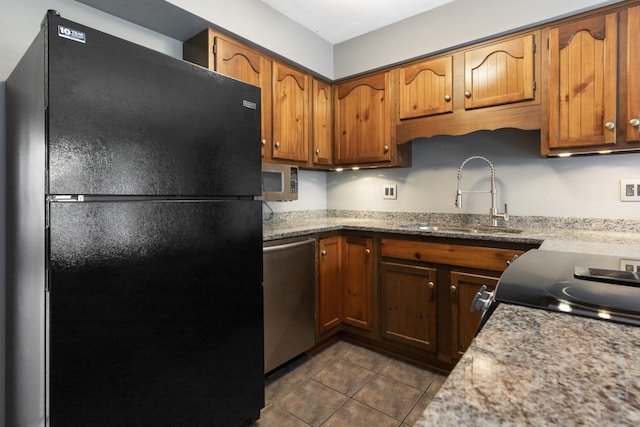 1485 Bryn Mawr Ln, Rockford, IL 61107 - kitchen with stainless steel appliances, dark tile patterned flooring, and brown cabinetry