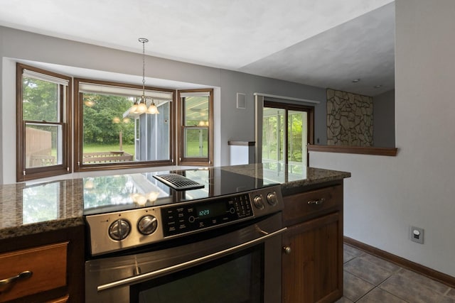 1485 Bryn Mawr Ln, Rockford, IL 61107 - kitchen with range, a chandelier, dark tile patterned floors, dark stone counters, and dark brown cabinets