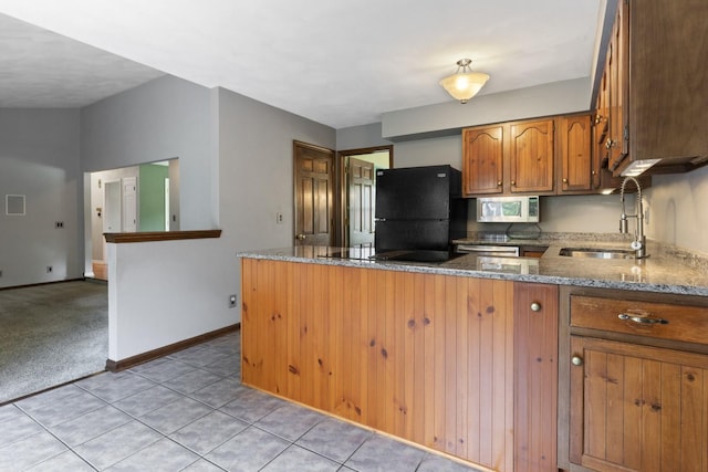 1485 Bryn Mawr Ln, Rockford, IL 61107 - kitchen with black appliances, brown cabinets, stone countertops, a peninsula, and light tile patterned flooring