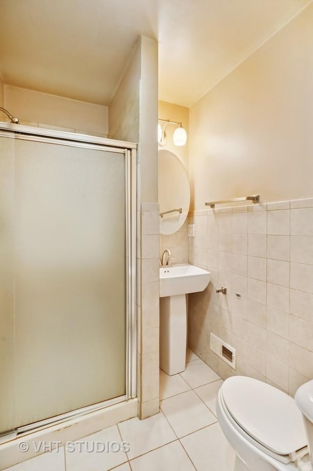 7241 N Mcvicker Ave, Chicago, IL 60646 - full bathroom with tile walls, a stall shower, tile patterned floors, and a wainscoted wall