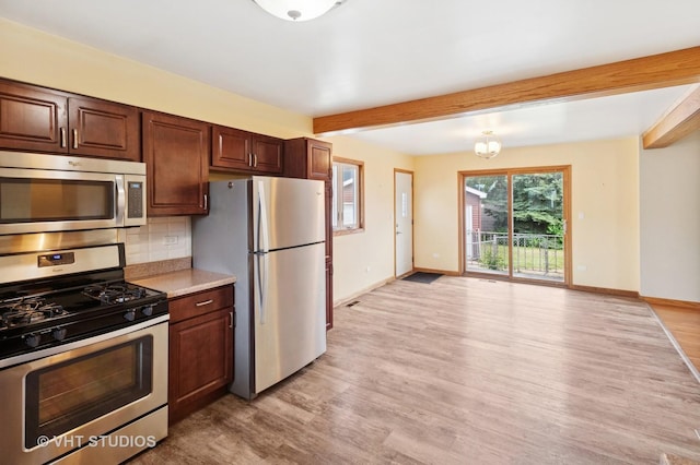 7241 N Mcvicker Ave, Chicago, IL 60646 - kitchen featuring stainless steel appliances, beamed ceiling, light wood finished floors, light countertops, and tasteful backsplash