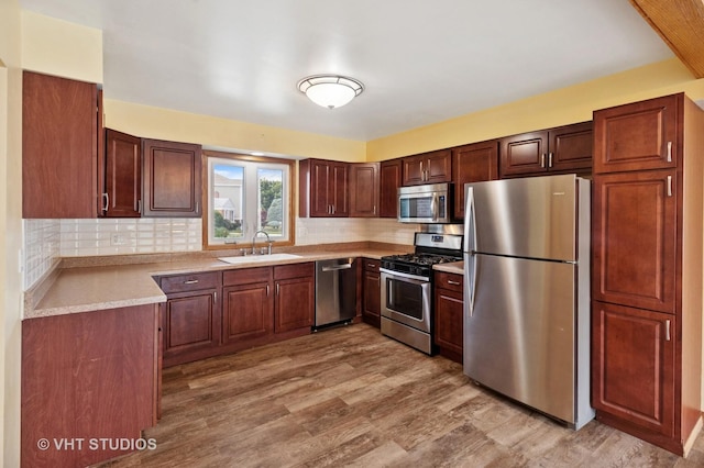 7241 N Mcvicker Ave, Chicago, IL 60646 - kitchen with appliances with stainless steel finishes, light wood finished floors, light countertops, and tasteful backsplash